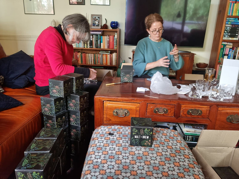 Mum and Grandma packing gift boxes at the coffee table, May 2021