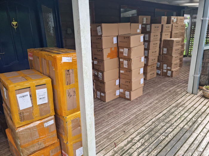 Cartons of Fuji and Twist glasses stacked on the front veranda, June 2021